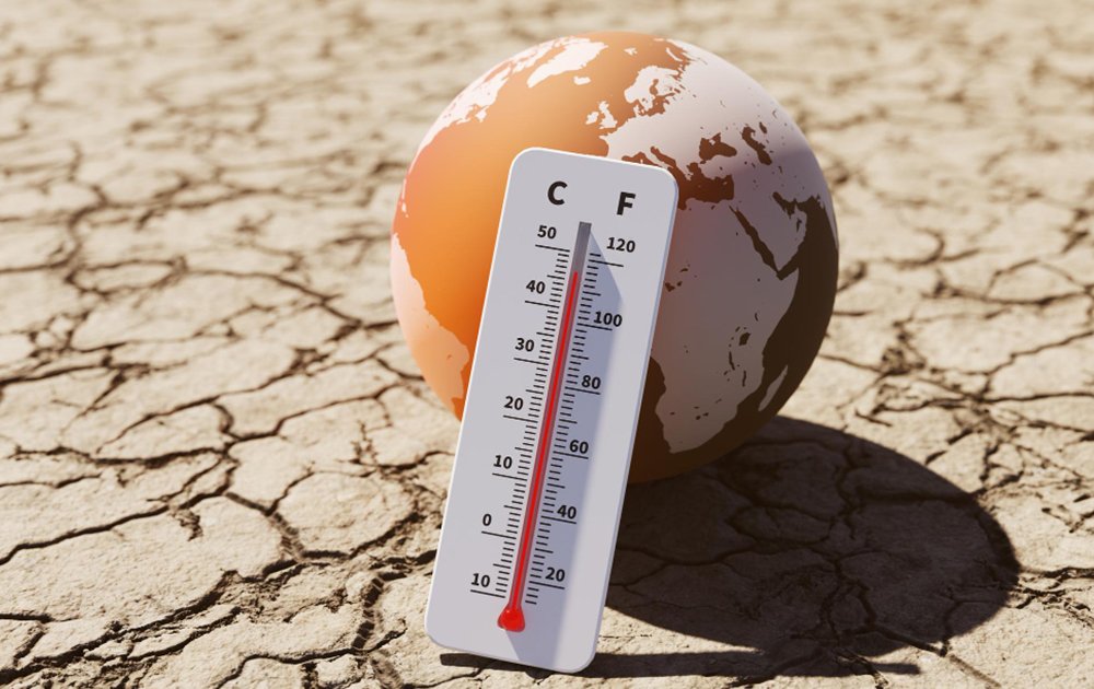 showing a temperature scale leaning on an earth globe with a background of drought land 